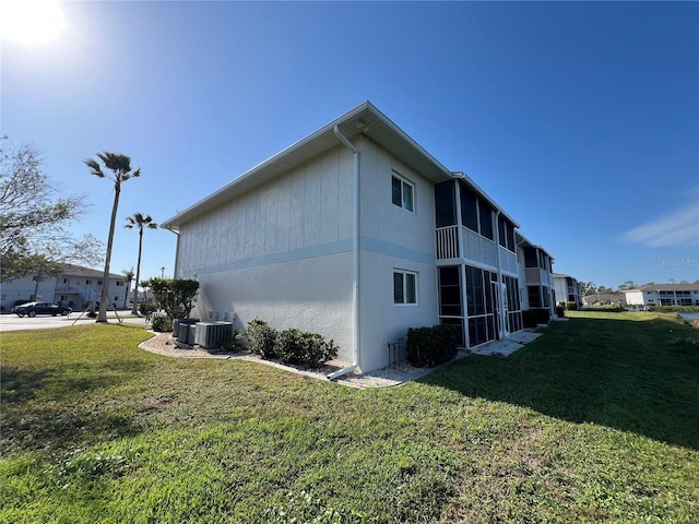 view of side of property with a yard and cooling unit