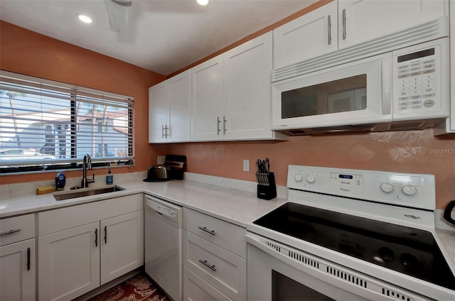 kitchen with white cabinetry, white appliances, and sink