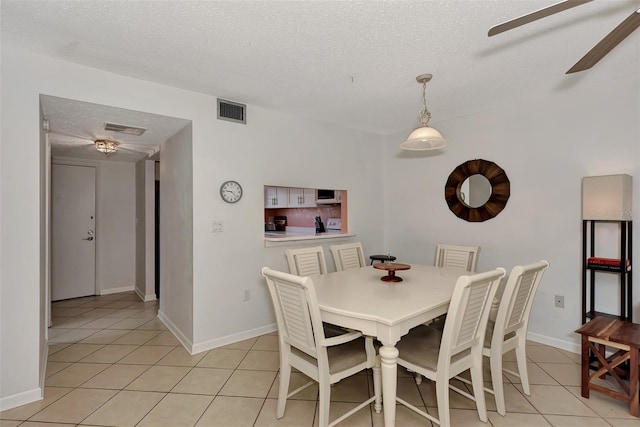 tiled dining space featuring ceiling fan and a textured ceiling