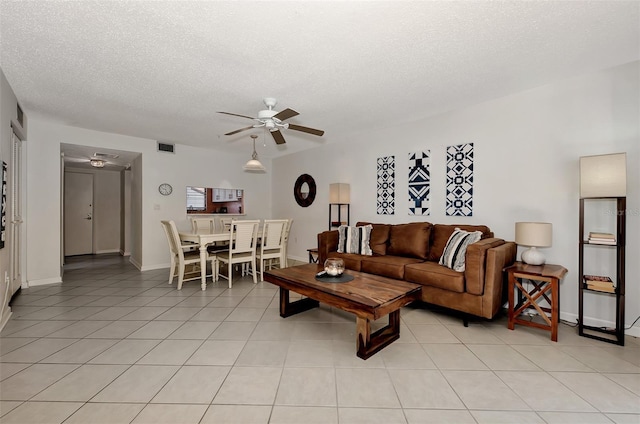 living room with light tile patterned floors, a textured ceiling, and ceiling fan