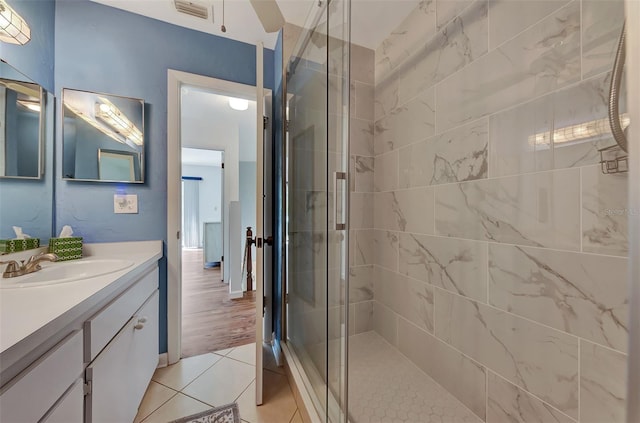 bathroom featuring tile patterned flooring, vanity, and walk in shower