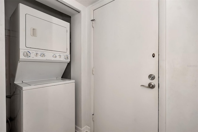 laundry room featuring stacked washer and dryer and a textured ceiling