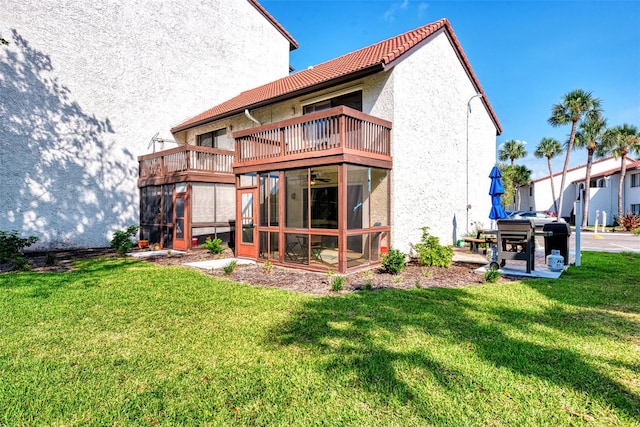 back of house with a balcony and a lawn