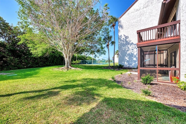 view of yard with a balcony and a sunroom