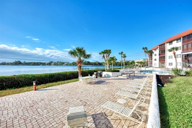 exterior space featuring a patio area, a water view, and a pool