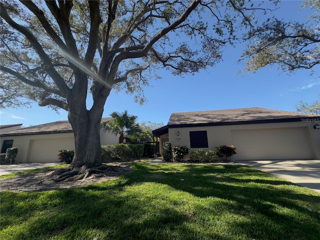 ranch-style home with a garage and a front lawn