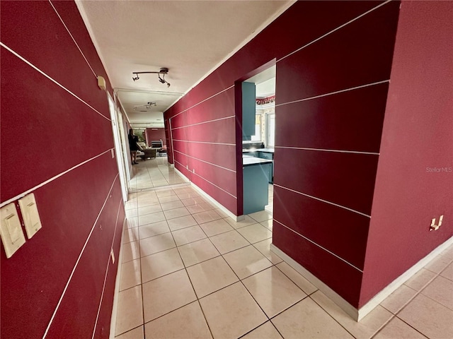 hallway with light tile patterned flooring and track lighting