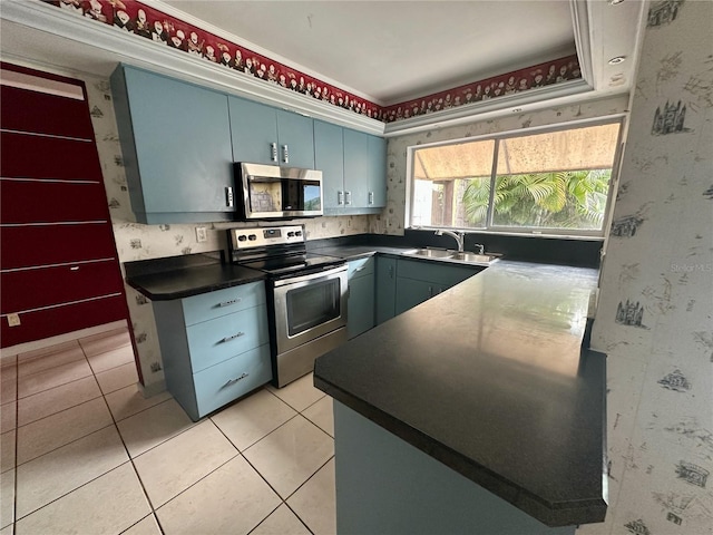 kitchen with blue cabinetry, sink, light tile patterned floors, ornamental molding, and appliances with stainless steel finishes