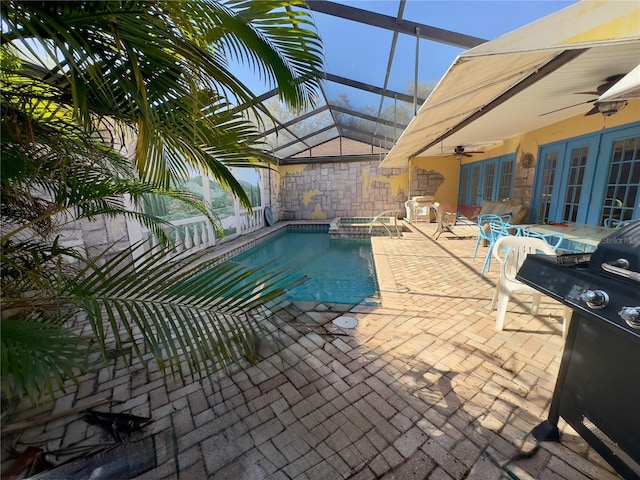 view of pool with french doors, a patio area, a lanai, an in ground hot tub, and ceiling fan