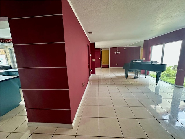 hallway featuring light tile patterned floors and a textured ceiling