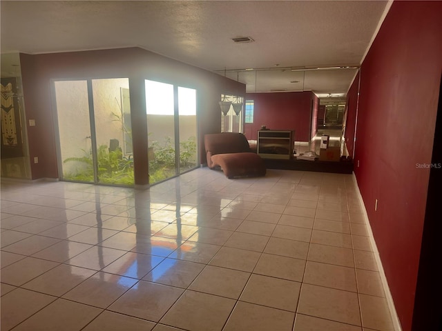 interior space with a textured ceiling and light tile patterned floors