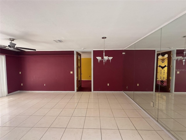 spare room featuring ceiling fan with notable chandelier and tile patterned flooring