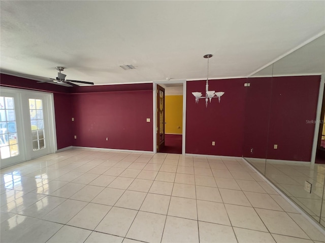 spare room with ceiling fan with notable chandelier and light tile patterned floors