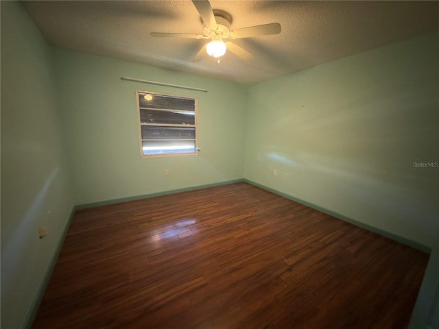 spare room with ceiling fan, dark hardwood / wood-style flooring, and a textured ceiling