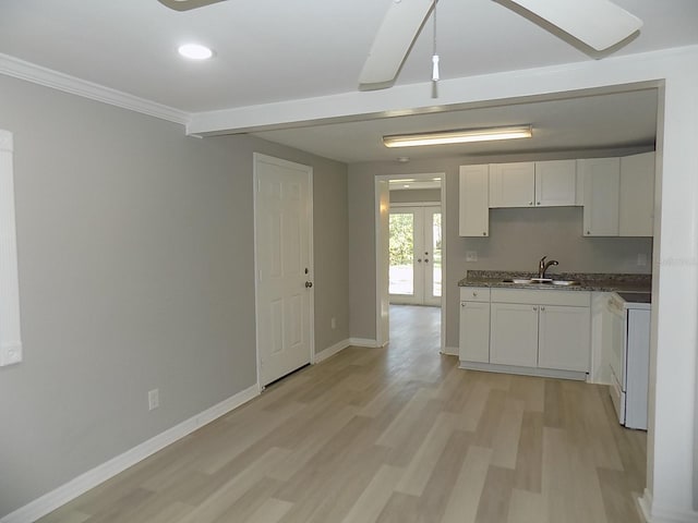 kitchen featuring white cabinets, range, french doors, and sink