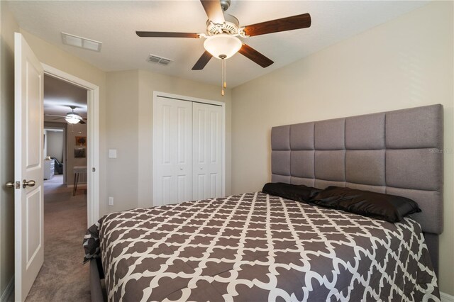 carpeted bedroom with ceiling fan and a closet