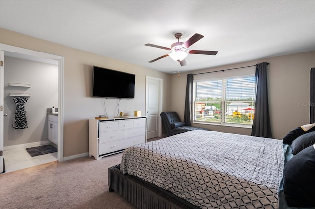 carpeted bedroom featuring ensuite bath and ceiling fan