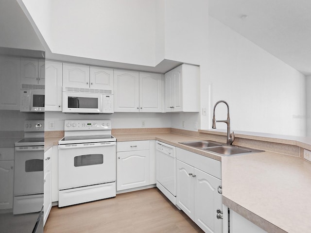 kitchen featuring white cabinets, light wood-type flooring, white appliances, and sink