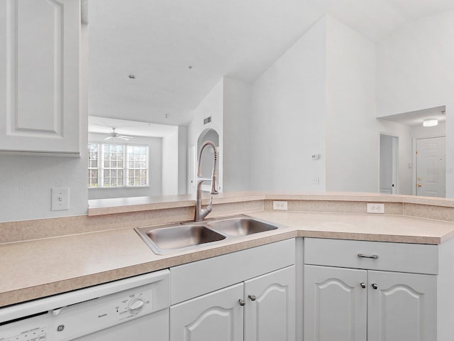 kitchen with white cabinets, white dishwasher, kitchen peninsula, and sink