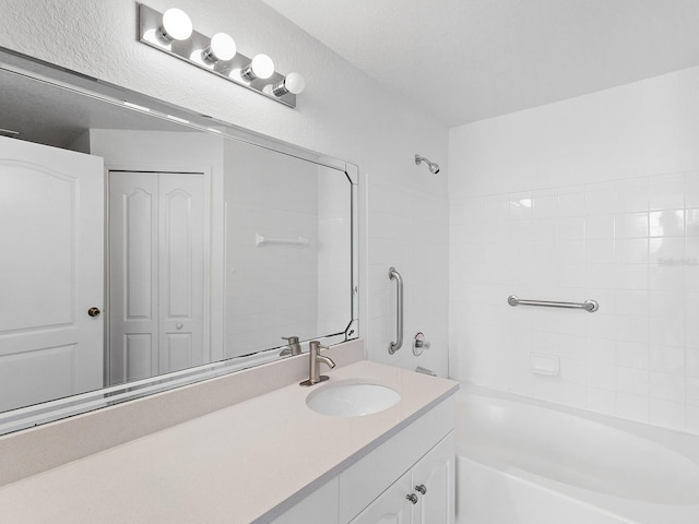 bathroom with bathtub / shower combination, a textured ceiling, and vanity