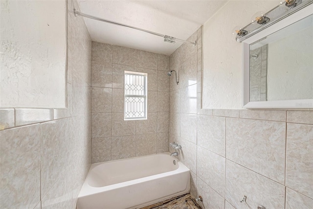 bathroom featuring tiled shower / bath combo and tile walls