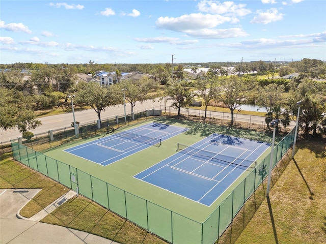 view of tennis court featuring a yard and a water view