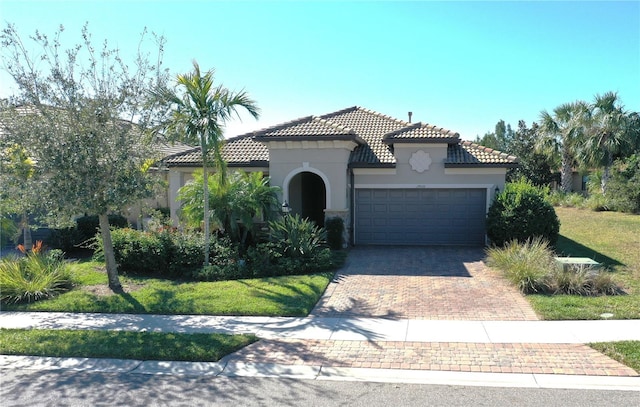 mediterranean / spanish home with a garage and a front lawn