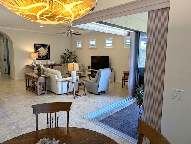 interior space with ornamental molding and ceiling fan