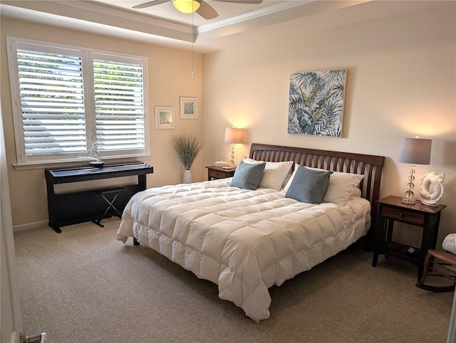 bedroom with ceiling fan, ornamental molding, a tray ceiling, and carpet