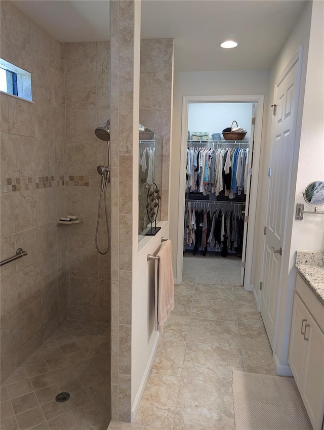 bathroom featuring vanity, plenty of natural light, and tiled shower