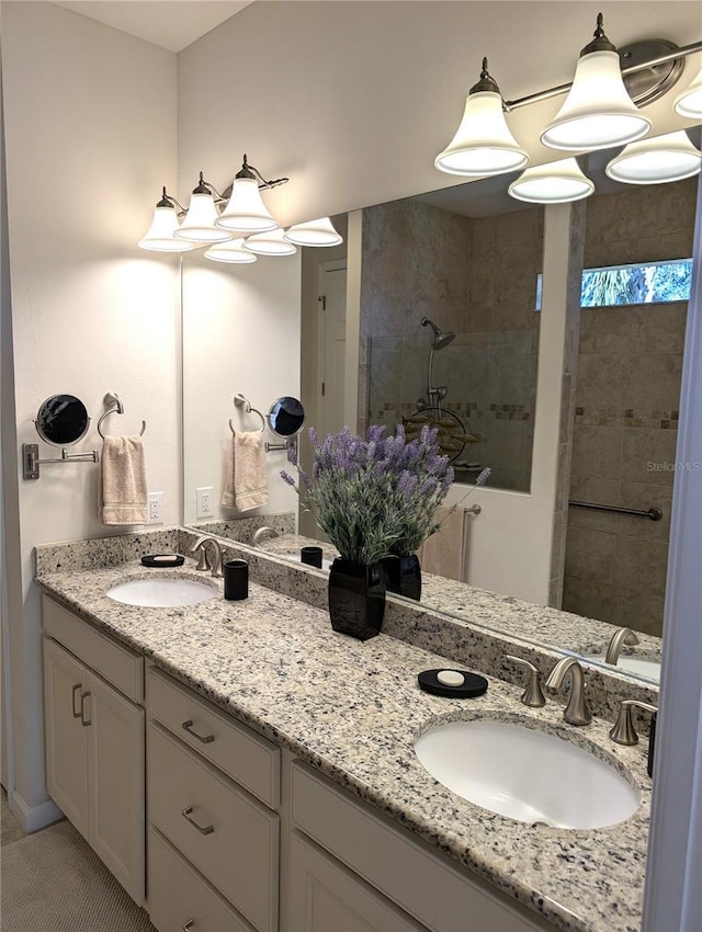 bathroom with vanity, a tile shower, and tile patterned floors