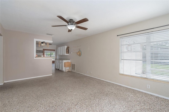 unfurnished living room featuring ceiling fan and a healthy amount of sunlight