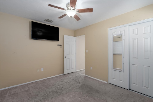 unfurnished bedroom featuring ceiling fan, a closet, and light colored carpet