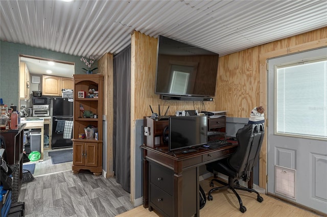 office featuring light hardwood / wood-style floors and wooden walls