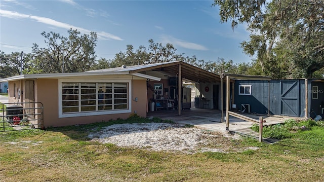 back of property with a yard and central AC