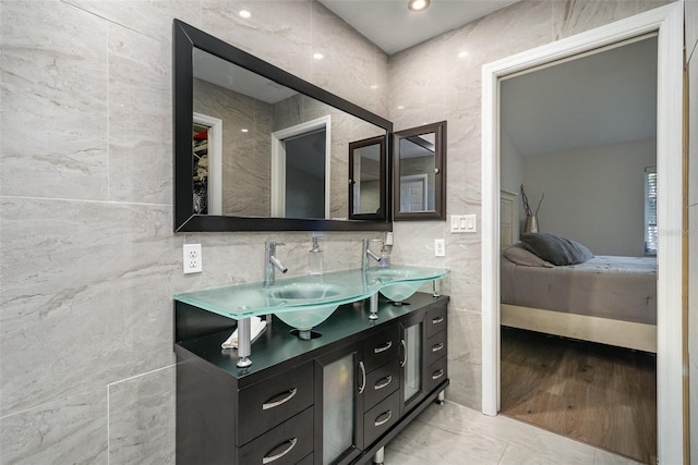 bathroom with tile patterned flooring, vanity, and tile walls