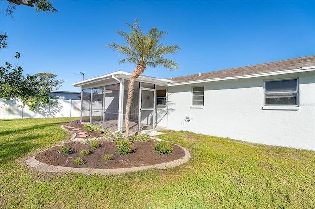 rear view of property with a yard and a sunroom