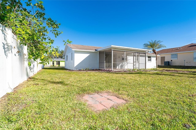 back of house with a yard, a sunroom, and central air condition unit