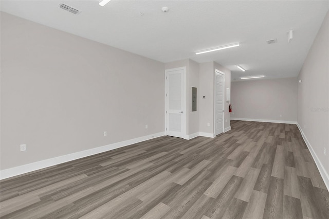 unfurnished living room with electric panel and wood-type flooring