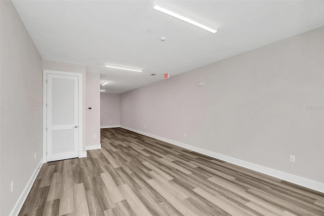 unfurnished room with a textured ceiling and light hardwood / wood-style flooring