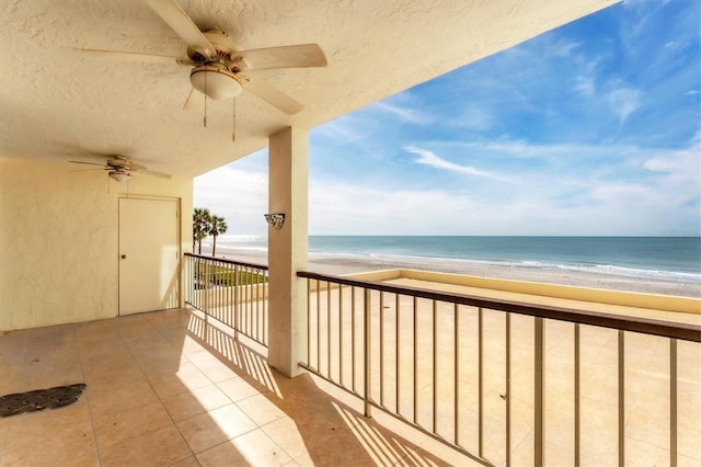 balcony featuring a water view and a beach view