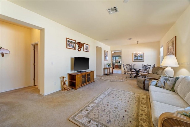 carpeted living room featuring a notable chandelier