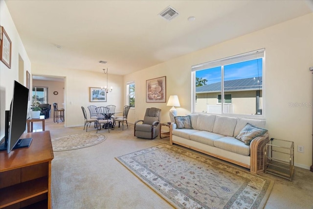 living room with a notable chandelier, carpet, and plenty of natural light