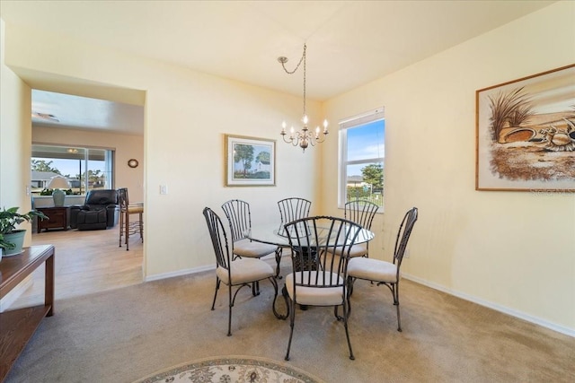 dining room featuring plenty of natural light, a notable chandelier, and light colored carpet