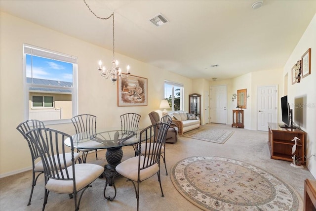 dining space with a chandelier and light colored carpet