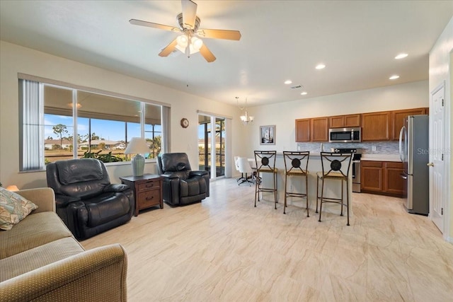 living room featuring ceiling fan with notable chandelier