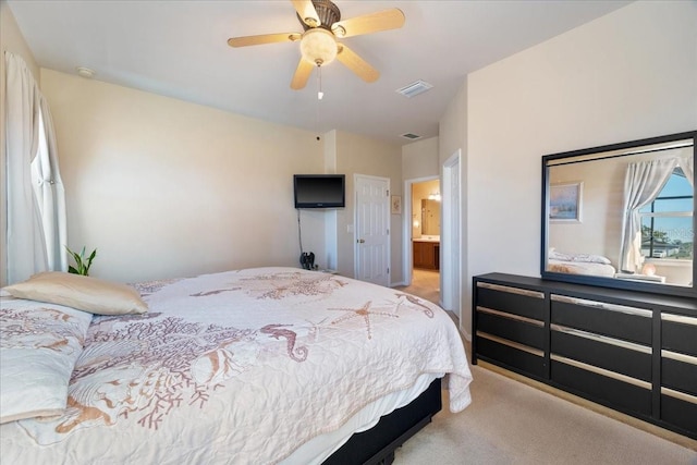 bedroom featuring ensuite bath, light colored carpet, and ceiling fan