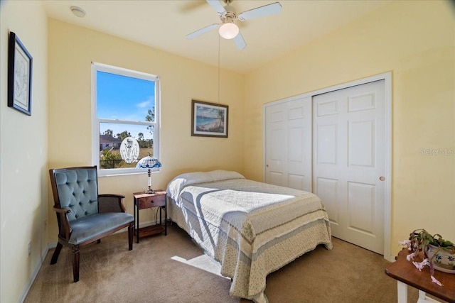 carpeted bedroom featuring ceiling fan and a closet