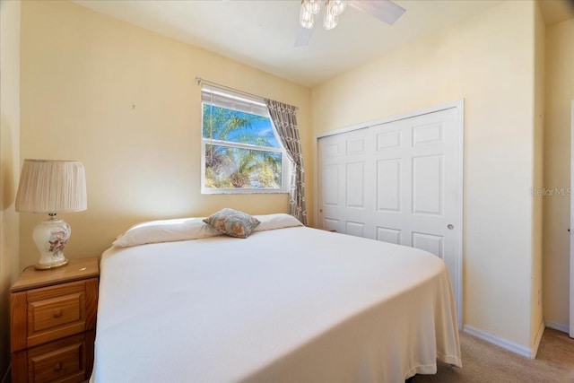 carpeted bedroom featuring ceiling fan and a closet