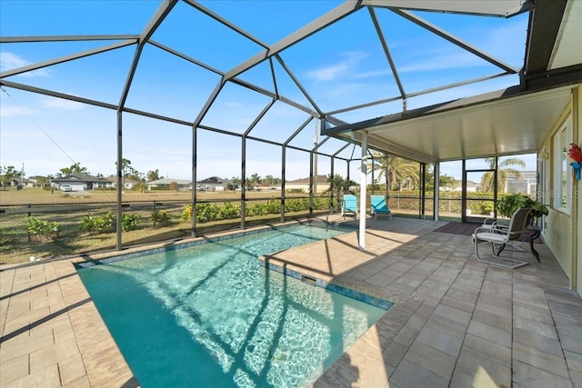 view of pool with glass enclosure and a patio